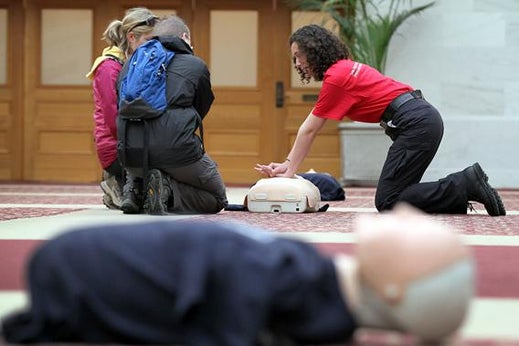 A volunteer with the San Francisco Paramedic Association teaches a couple how to perform CPR using a mannequin on June 1, 2011 in San Francisco, California.